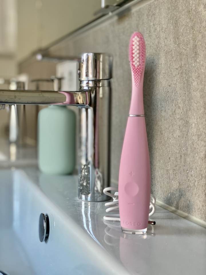 Zahnbürste mit Ladekabel am Waschbecken